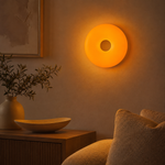 Lampe Halo murale ronde orange allumée, ouverture centrale circulaire