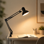 Lampe architecte noire à bras articulés, abat-jour orienté au-dessus d’un bureau