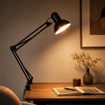 Lampe architecte noire à bras articulés et abat-jour orientable, éclairant une table