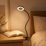 Lampe de lecture LED noire à col flexible, tête circulaire éclairant un livre ouvert