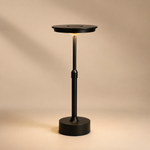 Lampe Flambeau sur pied, abat-jour rond noir, tige dorée et base noire.