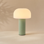Lampe d’ambiance Portobello : abat-jour opale blanc, base cylindrique vert et bouton argent.