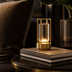 Lampe Fanal dorée sur livres, lanterne en verre rectangulaire et base cylindrique