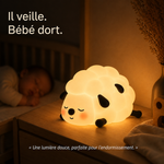 Veilleuse mouton allumée sur table, yeux fermés, forme en nuage