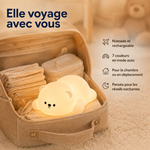 Veilleuse ourson en silicone blanc, dans une trousse de voyage, lumière allumée