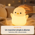 Veilleuse manchot lumineuse sur tissu, coque blanche, bec jaune, forme arrondie.