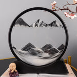 Lampe sablier cinétique LED ronde, relief noir et blanc de montagnes sur base sombre.