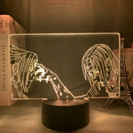 Veilleuse LED 3D manga sur socle noir, deux personnages en vis-à-vis, contours dorés.