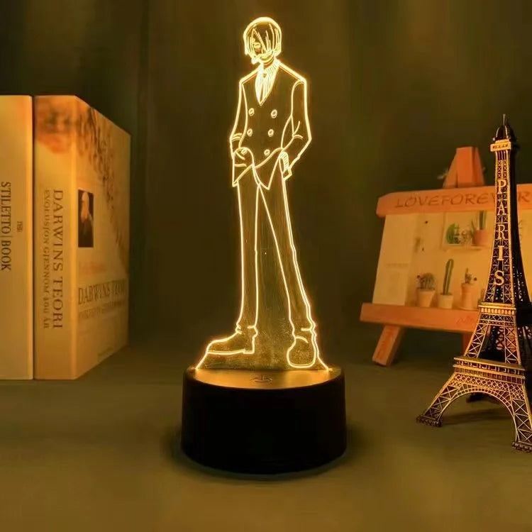 Lampe LED 3D personnage en lignes dorées, socle noir cylindrique.