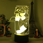 Veilleuse LED 3D manga sur socle noir, silhouette de personnage aux contours jaunes.